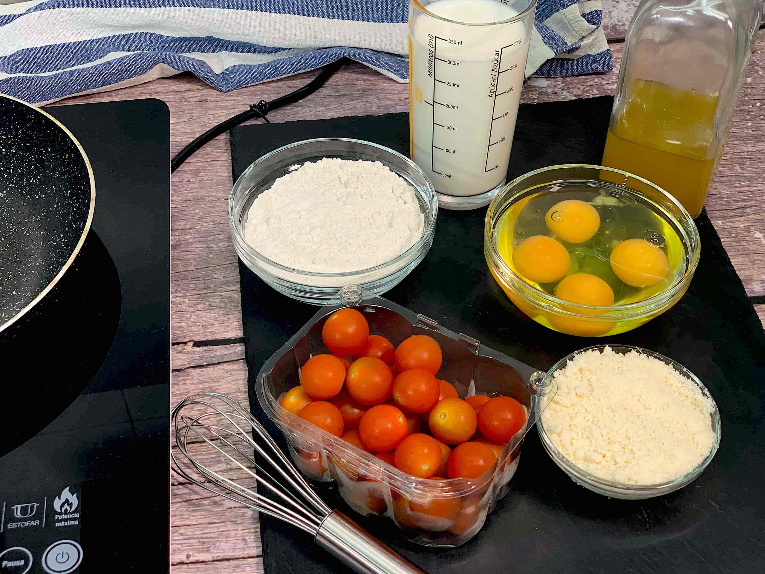 Ingredientes para pastel salado de tomates cherry: huevos, leche entera, queso parmesano, harina, tomates cherry y aceite de oliva.